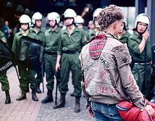 Un punk frente a un grupo de policías